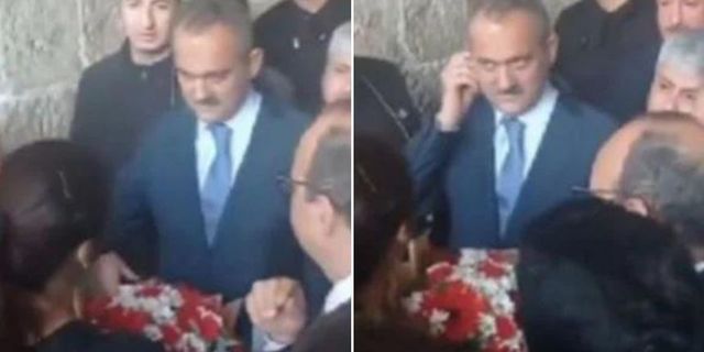 Öğretmenin uzattığı çiçeği almayan Bakan Mahmut Özer kulağını kaşıdı